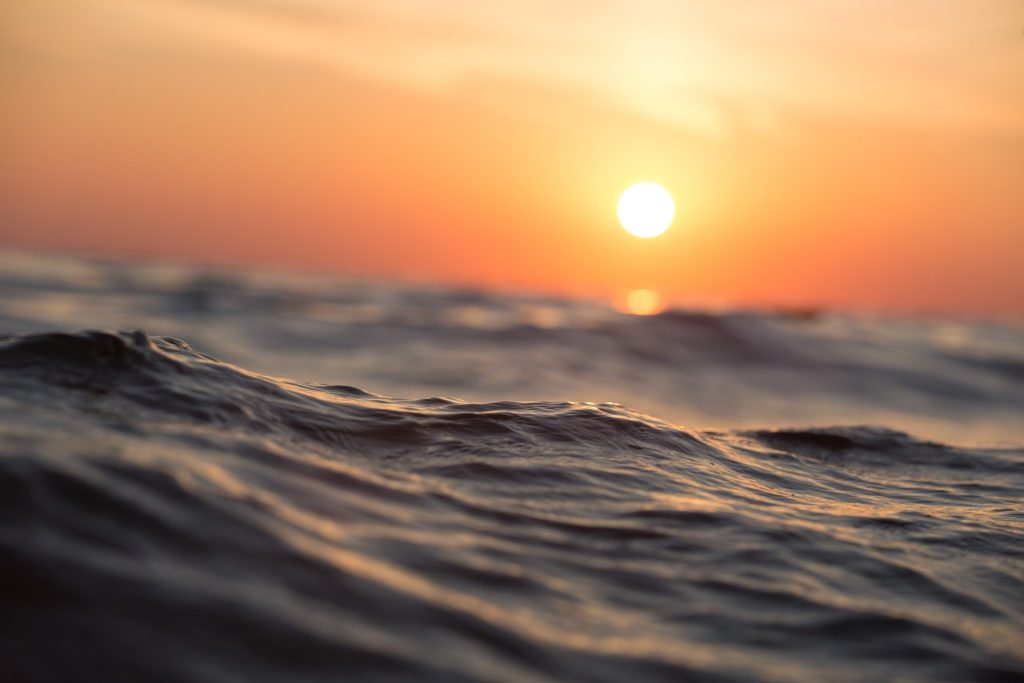 Want to build resilience? Be like the gentle waves floating beneath a setting sun and an orange sunset.